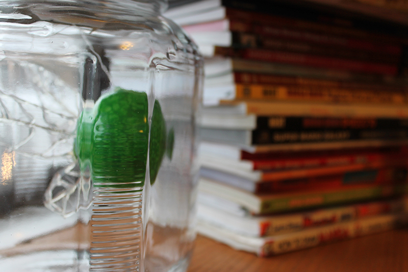 glass fairy in a jar with books in the background